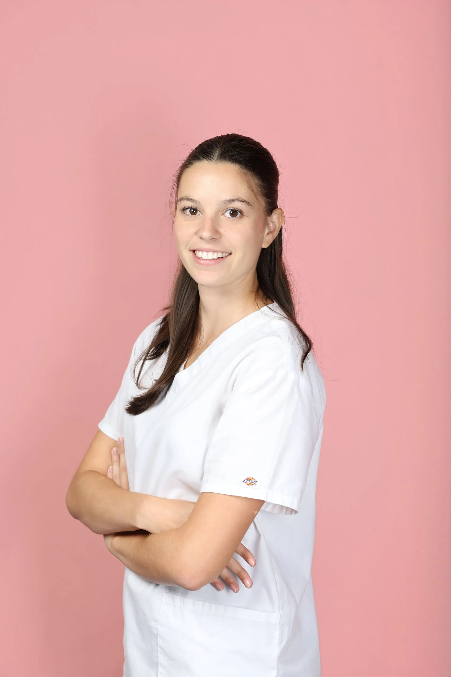 Carla Gallice, en tenue de praticienne, les bras croisés.